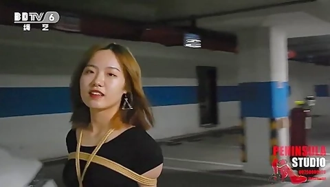 Young Chinese Girl Walks Around Carpark Tied Up